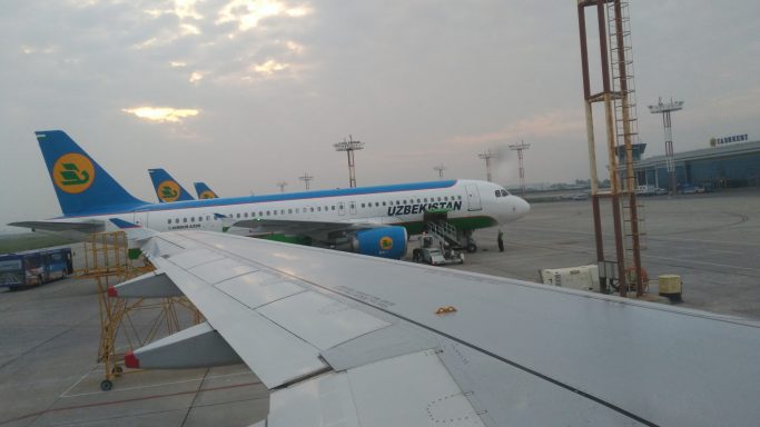 Aviones estacionados en el aeropuerto con un cielo nublado al fondo.